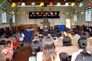 A congregation in church with a person at the pulpit.
