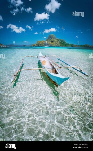 traditional-filippino-fisher-banca-boat-in-blue-lagoon-at-el-nido-bay-with-cadlao-island-on-ba...jpg