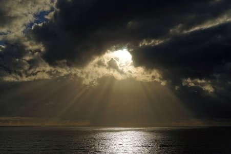 Sun_breaking_through_clouds_over_ocean.jpg