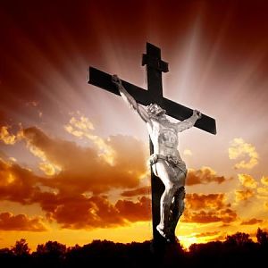 Christian cross with Jesus Christ in beautiful sunrise