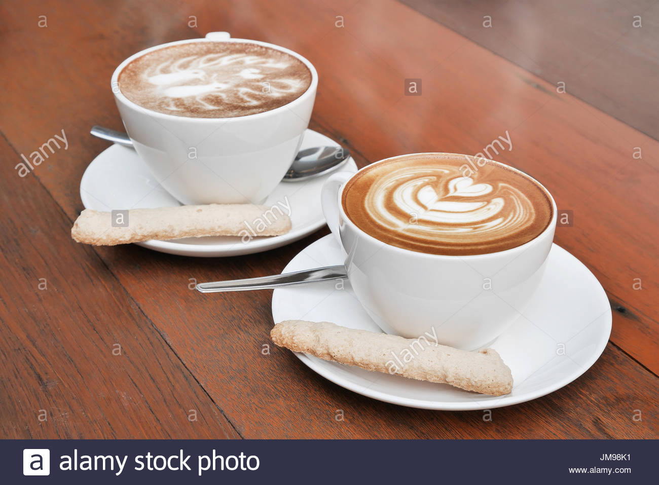 two-cups-of-latte-art-coffee-in-a-white-cup-on-wooden-background-JM98K1.jpg