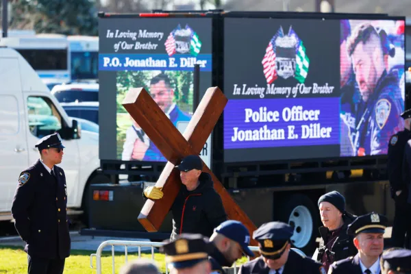 A man holds a cross outside the funeral of NYPD officer Jonathan Diller at St. Rose of Lima Catholic Church on Holy Saturday, March 30, 2024, in Massapequa, New York. Credit: Michael M. Santiago/Getty Images