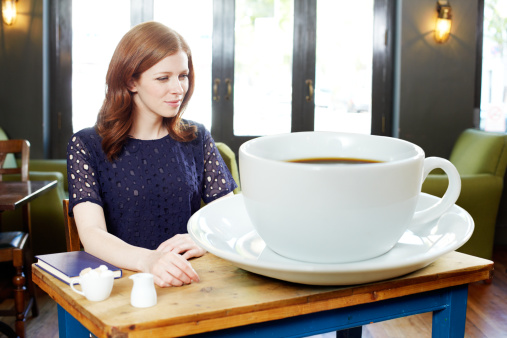 117845402-woman-in-coffee-shop-with-huge-coffee-gettyimages.jpg