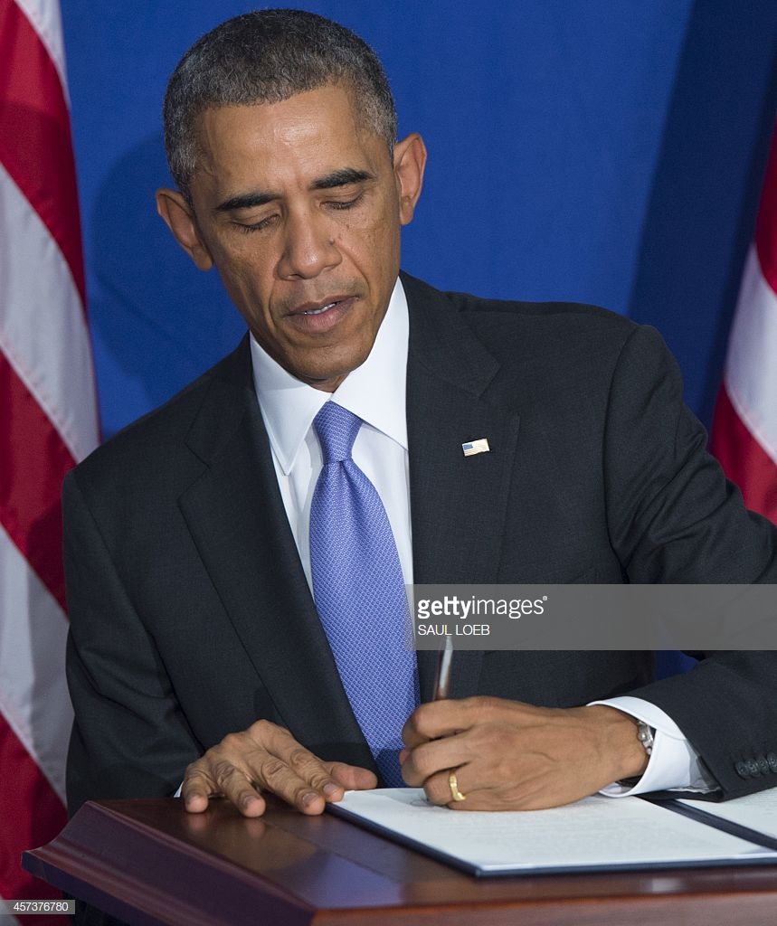 president-barack-obama-signs-an-executive-order-to-implement-enhanced-picture-id457376780