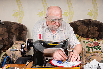 senior-man-doing-needlepoint-sewing-machine-serious-wearing-eyeglasses-working-needle-point-wall-hanging-craft-using-old-56954810.jpg