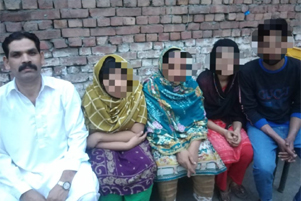 Sawan Masih sitting with his family; all faces pixelated except Sawan's.