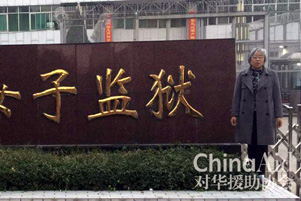 Yang Rongli standing beside a sign.