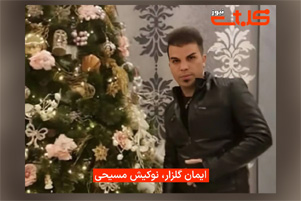 Iman Golzar is standing next to a Christmas tree.