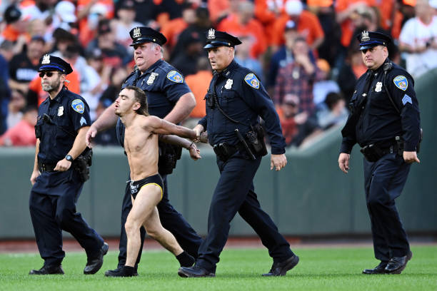 Field invader is apprehended by police during the eighth inning of Game One of the American League Division Series between the Baltimore Orioles and...