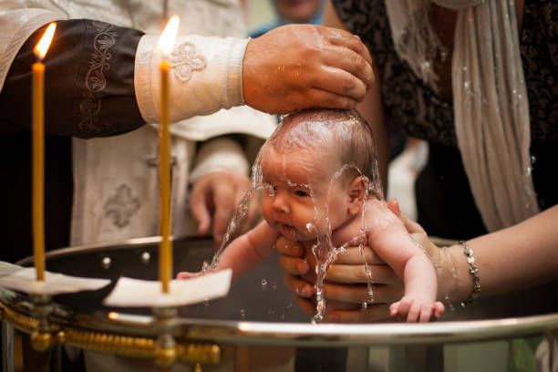 newborn-baby-baptism-in-holy-water-baby-holding-mothers-hands-infant-picture-id1167481061