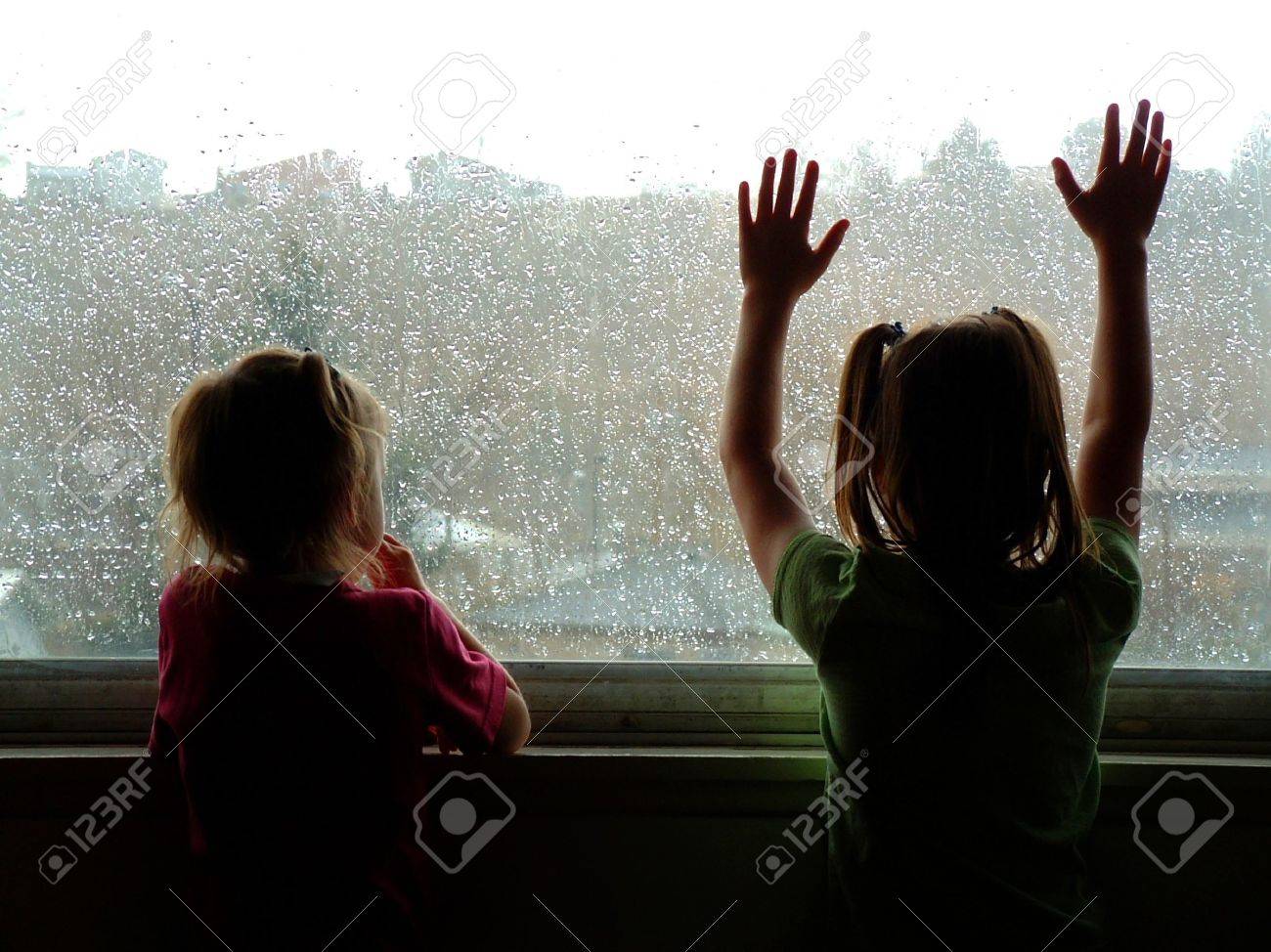 579243-two-little-kids-looking-out-window-on-rainy-day-Stock-Photo.jpg