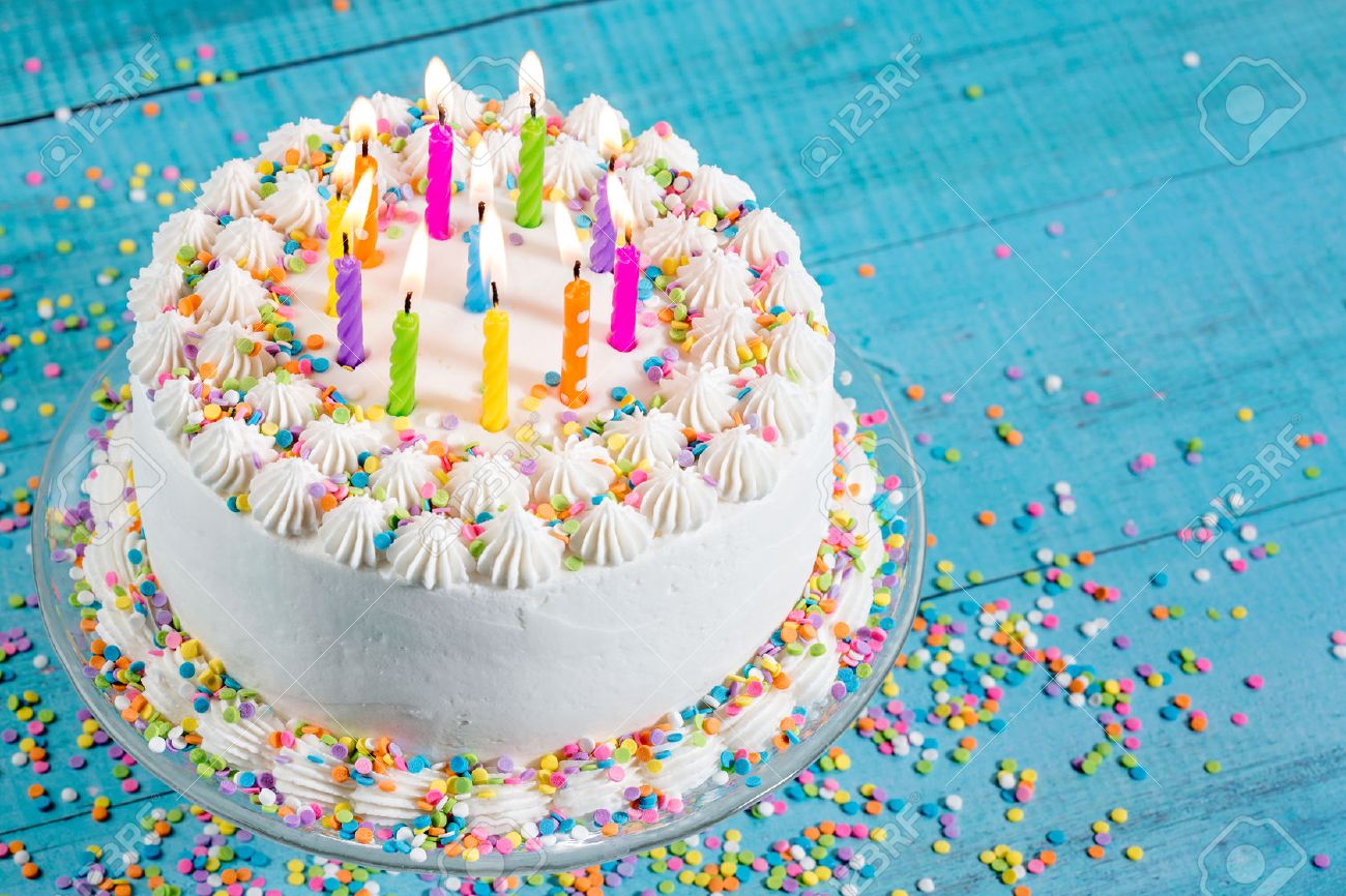 52937243-white-buttercream-icing-birthday-cake-with-with-colorful-sprinkles-and-candles-over-blue-background.jpg