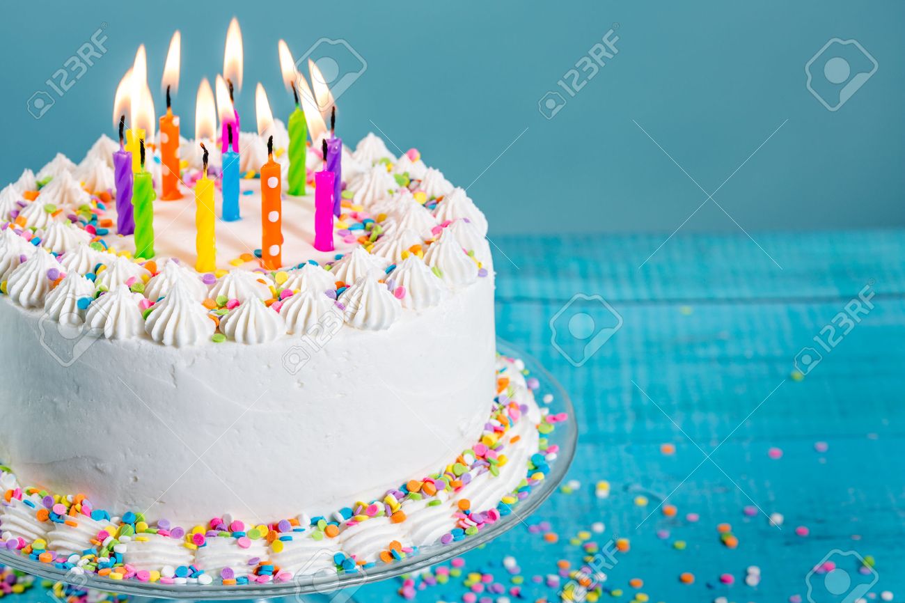 52937248-white-buttercream-icing-birthday-cake-with-with-colorful-sprinkles-and-candles-over-blue-background.jpg