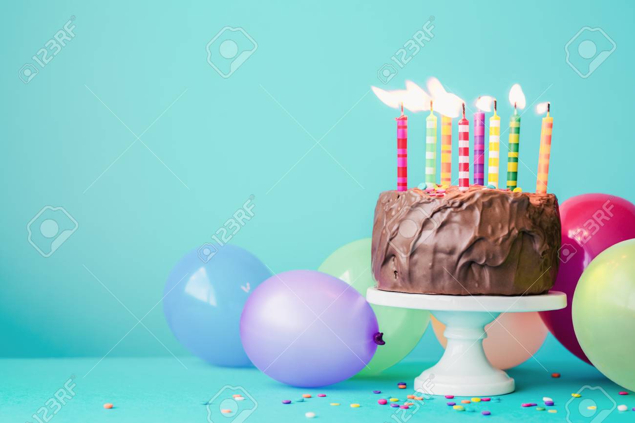 102331491-chocolate-birthday-cake-with-colorful-candles-and-balloons.jpg