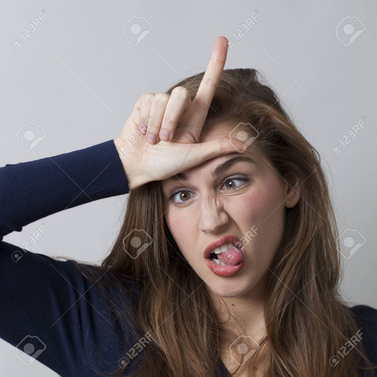 52422716-silly-young-woman-making-the-l-sign-on-forehead-for-loser-message-cool-hand-gesture-for-youth-cultur.jpg