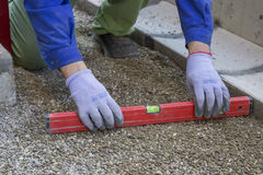 worker-checking-horizontal-level-ground-paving-leveling-tool-36717051.jpg