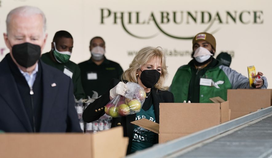 First lady Jill Biden packs produce as she and President Joe Biden volunteer at hunger relief organization Philabundance, Sunday, Jan. 16, 2022, in Philadelphia. (AP Photo/Patrick Semansky)