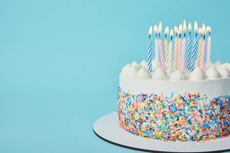 112251082-delicious-birthday-cake-with-lighting-candles-on-blue-background.jpg